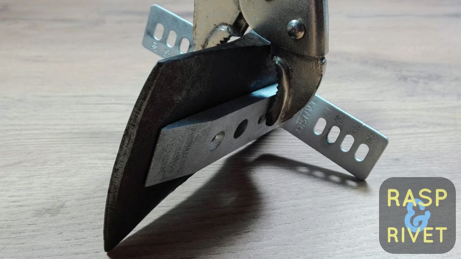 A vice grip securing the two parts of the knife clamp to the axe. A vice grip securing the two parts of the knife clamp to the axe.