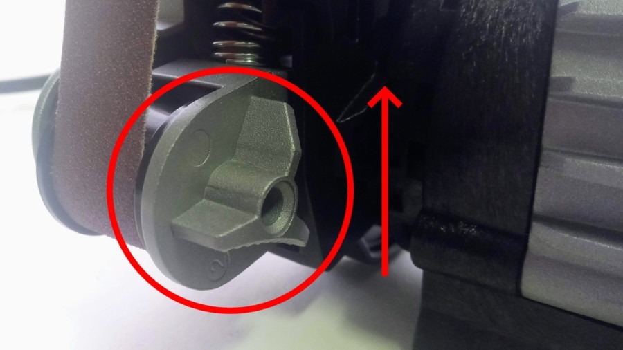 Push the spring-loaded belt change lever up. Push the spring-loaded belt change lever up.